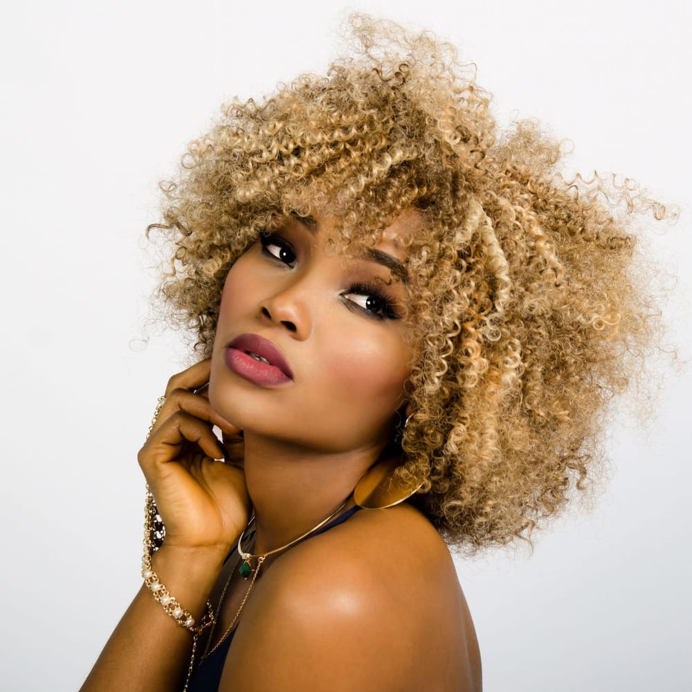 Donna sorridente con capelli ricci biondi